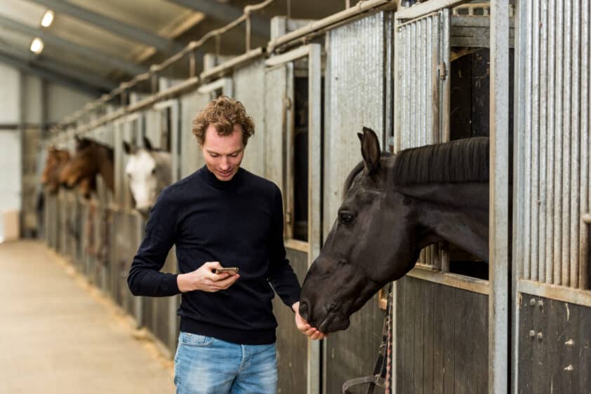 EquineM user with horse and mobile phone in hand